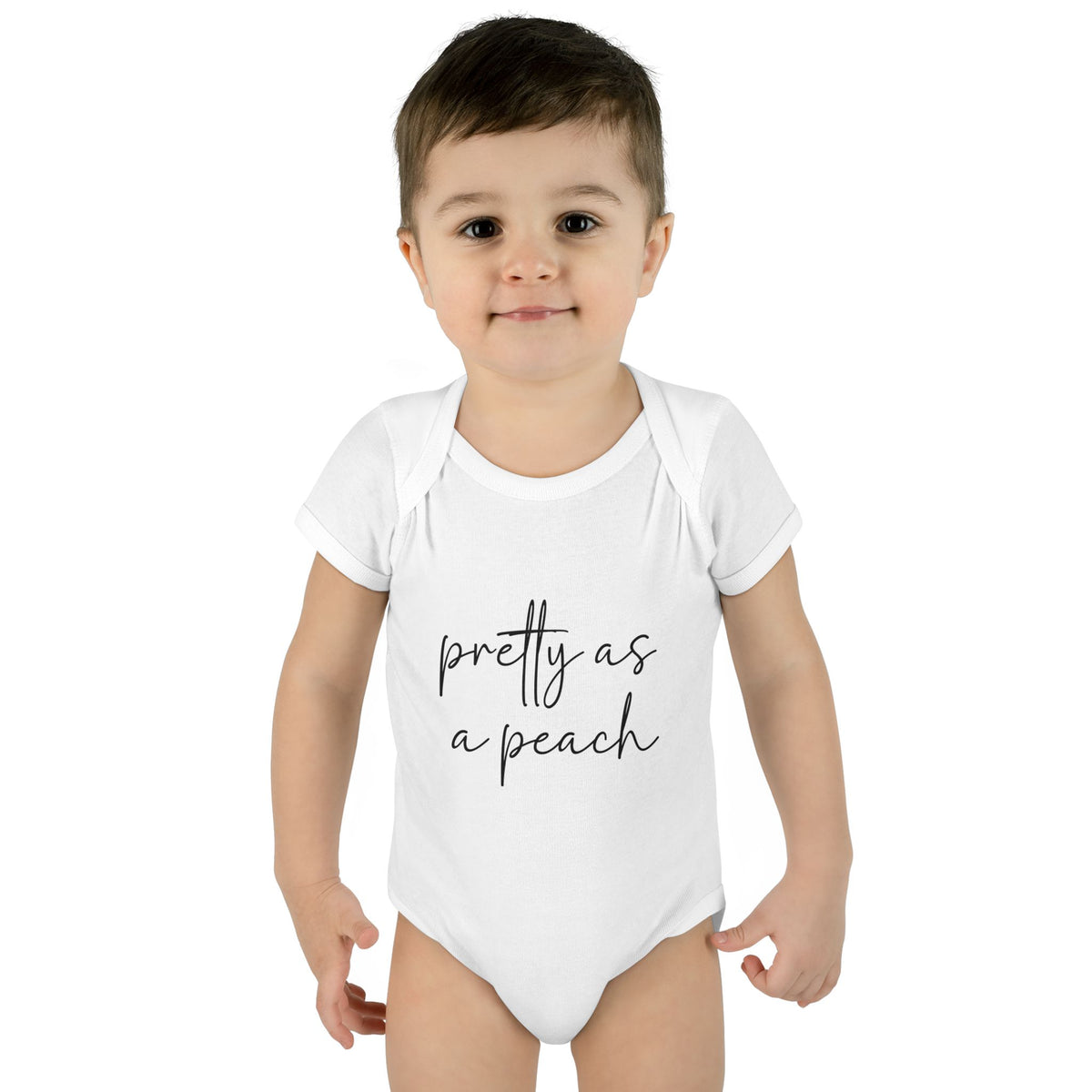White Pretty as a Peach baby bodysuit, worn on a toddler model.