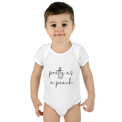 White Pretty as a Peach baby bodysuit, worn on a toddler model.