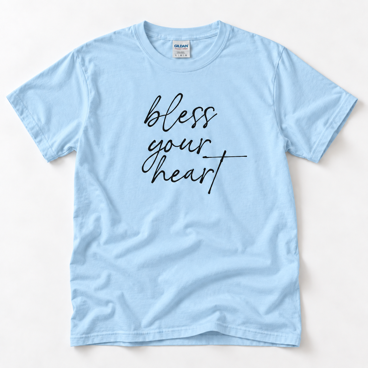 Light Blue Bless Your Heart adult T-shirt laid flat with black script lettering.