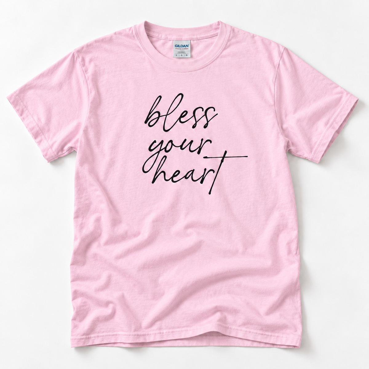Light Pink Bless Your Heart adult T-shirt laid flat with black script lettering.