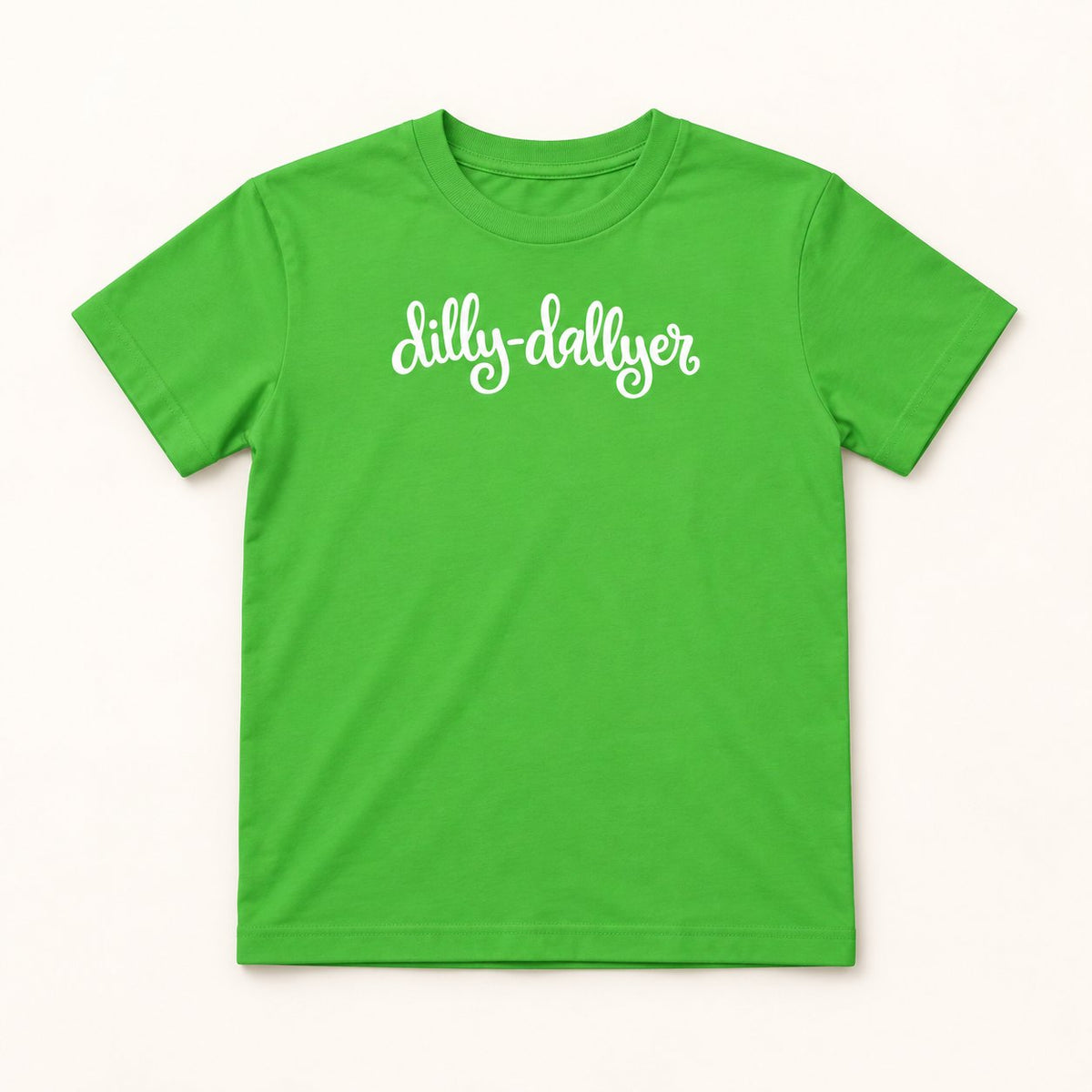 Apple Dilly-Dallyer kids tee with white script, flat on a cream background