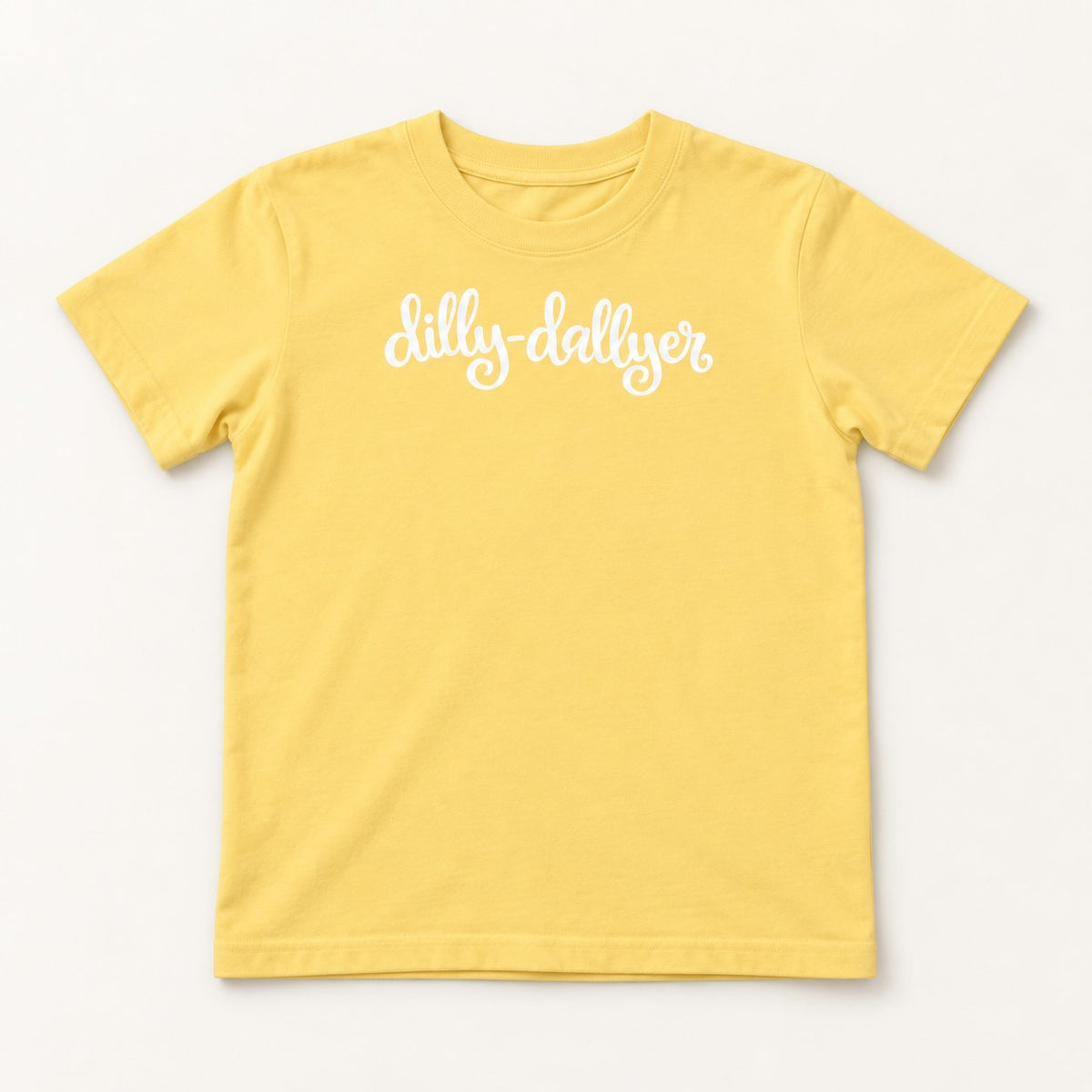 Butter Dilly-Dallyer kids tee with white script, flat on a cream background