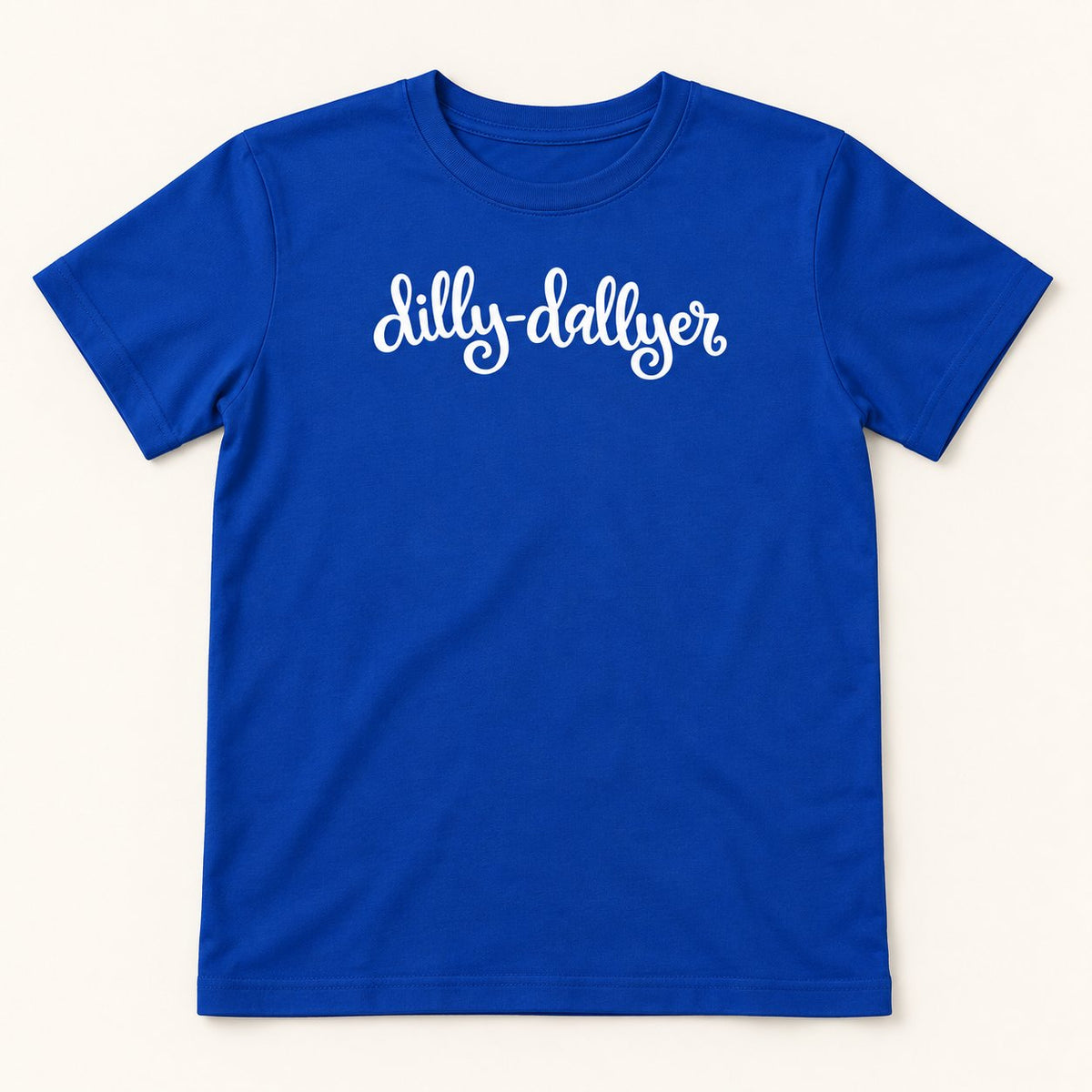 Royal Dilly-Dallyer kids tee with white script, flat on a cream background