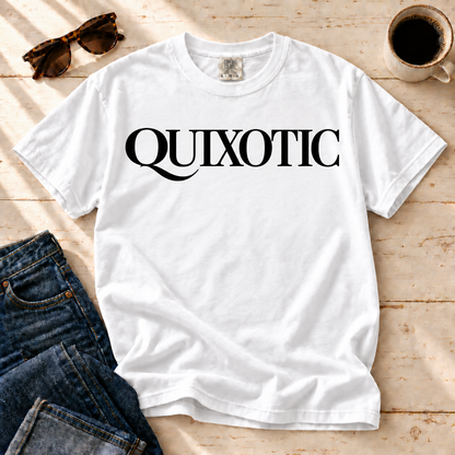 White Quixotic tee laid flat with jeans, sunglasses, and coffee.
